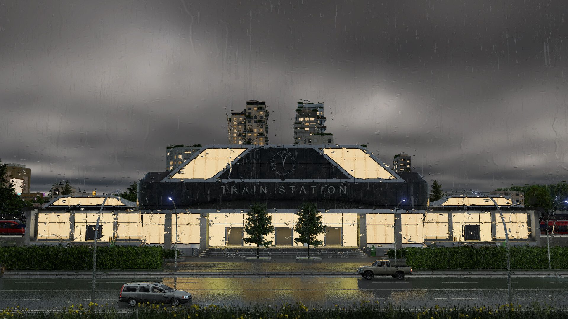 A modern glass train station lit up at night in the rain, with high-rise buildings behind it